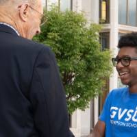 Robert Thompson shaking a Thompson Scholar's hand outside.